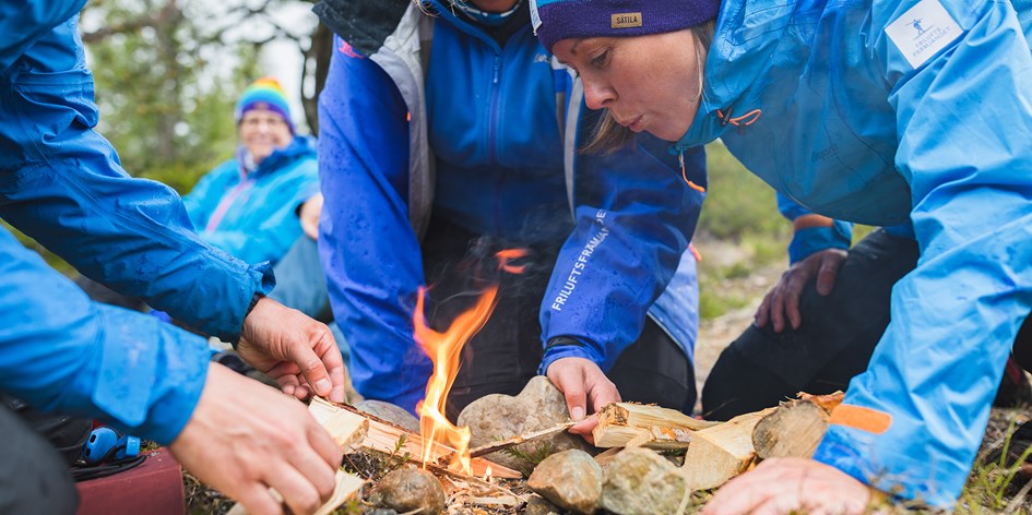 En grupp ledare gör upp eld utomhus