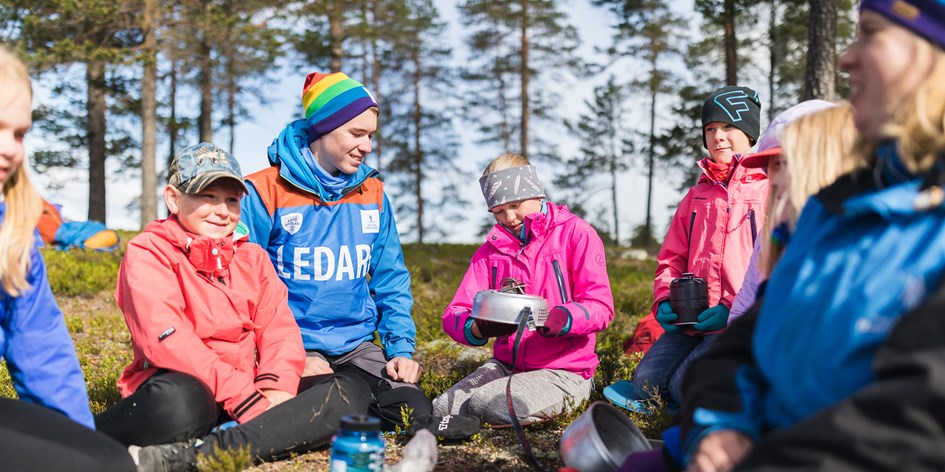 En grupp med ledare och barn övar på att använda stormkök