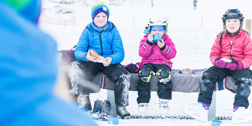 Barn fikar vid skridskobana