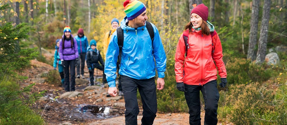 Ledare och grupp vandrar i höstskog
