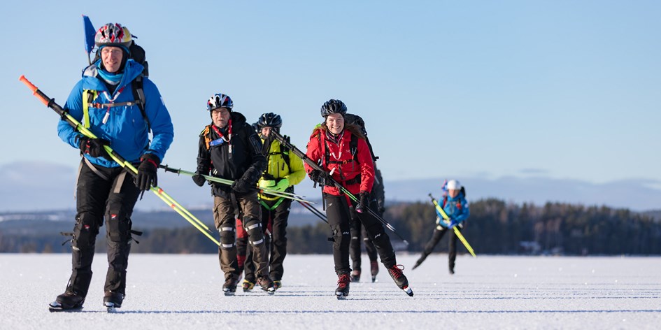 Grupp på långfärdsskridskor åker på tur tillsammans med ledare