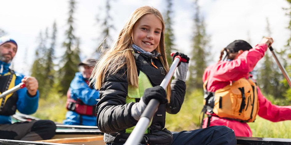Barn och vuxna paddlar kajak tillsammans