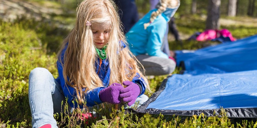 Barn hjälps åt att spänna fast tarp